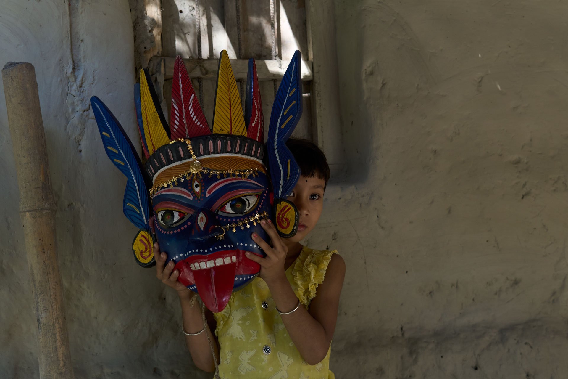Colorful Gomira mask placed indoors, showing traditional handcrafted details.